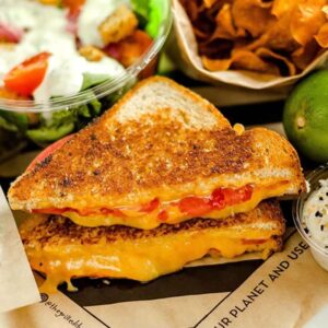 Grilled cheese sandwich meal with salad and chips